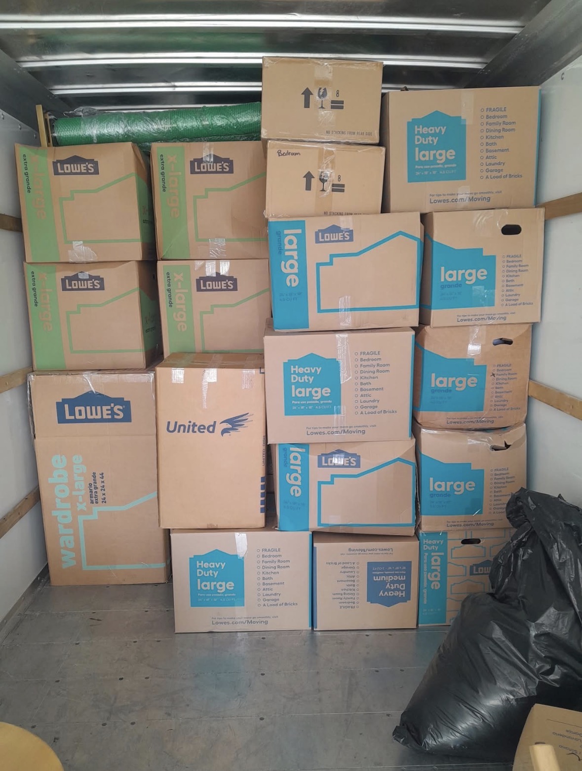 A KJ's Moving Company truck loaded floor to ceiling with carefully stacked boxes